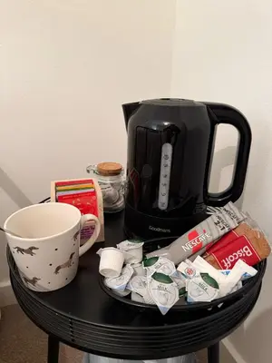 a table with a coffee maker and a coffee cup at Single room with beautiful garden in Edinburgh