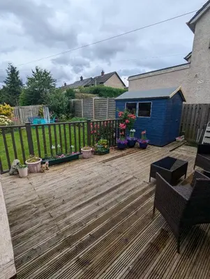 a wooden deck with potted plants and a fence at Single room with beautiful garden in Edinburgh