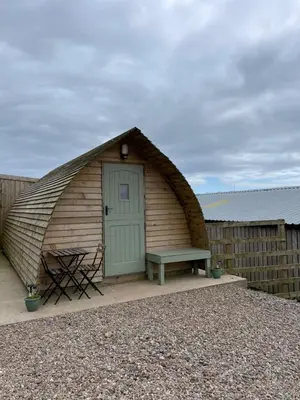 a igloo house with a bench and a door at Penny gown farm pod in Campbeltown