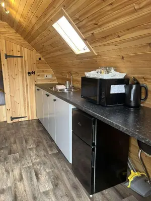 a kitchen with a microwave on top of a counter at Penny gown farm pod in Campbeltown