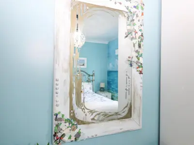 a mirror hanging on a wall in a room at Hazel's Cottage in Campbeltown