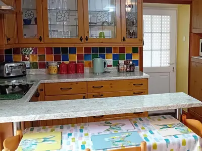 a kitchen with wooden cabinets and a counter top at Hazel's Cottage in Campbeltown