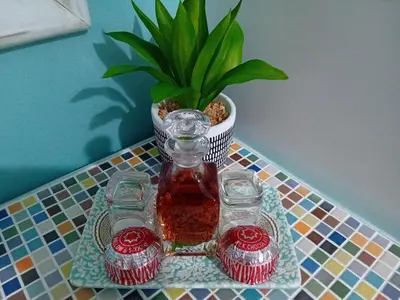 a vase on a table with cupcakes and a plant at Hazel's Cottage in Campbeltown