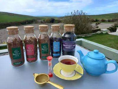 a table with four bottles and a cup of tea at Hazel's Cottage in Campbeltown