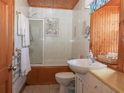 a bathroom with a sink and a toilet and a shower at Hazel's Cottage in Campbeltown