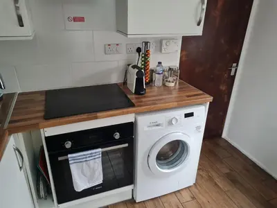a kitchen with a washer and dryer on a counter at 223 Websters land - stunning castle view in Edinburgh