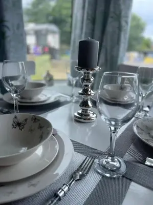 a table with plates and glasses and a candle on it at 2 Bedrooms Holiday home in Edinburgh near City Center in Edinburgh
