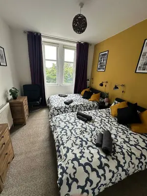 a bedroom with two beds and a window at Clydebank Cozy 3bdr flat near Glasgow in Clydebank