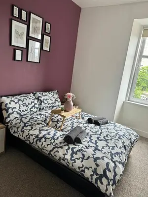 a bedroom with a bed and a table with hats on it at Clydebank Cozy 3bdr flat near Glasgow in Clydebank