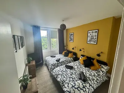 a bedroom with two beds and a window at Clydebank Cozy 3bdr flat near Glasgow in Clydebank