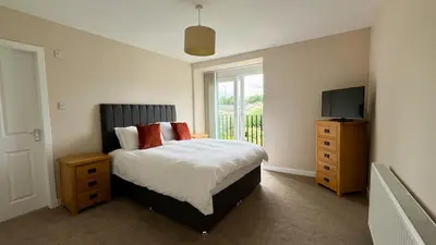a bedroom with a bed with a television and a dresser at 19 Snowdon Apartment in Stirling