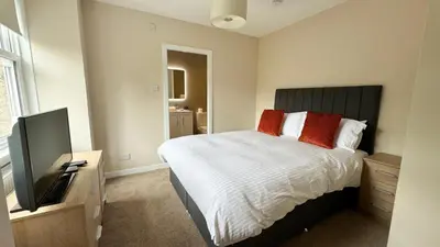 a bedroom with a bed and a flat screen tv at 19 Snowdon Apartment in Stirling