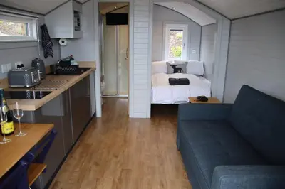 a kitchen and a living room with a bed and a couch at Kintyre Glamping Pods in Campbeltown