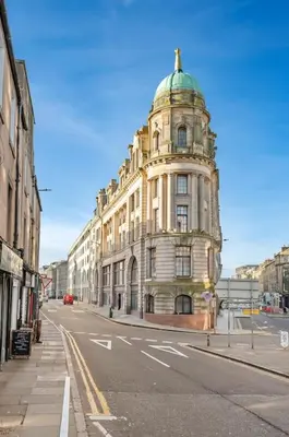 a tall building with a green dome on a city street at Two Bedroom Apartment-Central Edinburgh-Old Town-licensed in Edinburgh