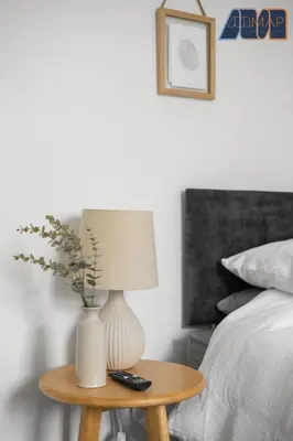a table with a lamp on it next to a bed at High Street Haven in Kincardine in Kincardine