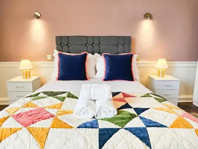 a bedroom with a bed with a colorful quilt at Spacious 2 Bedroom Apartment in the heart of New Town in Edinburgh