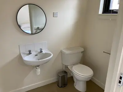 a bathroom with a sink and a toilet and a mirror at Linlithgow Hostel in Linlithgow