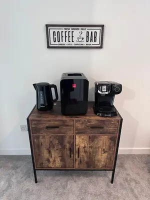 a coffee table with a coffee and bar sign on it at The Orchard Suite in Dalserf