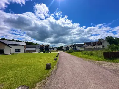 a dirt road in a village with houses at The Orchard Suite in Dalserf