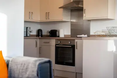 a kitchen with white cabinets and an oven at Aberlour Apartment in Oban