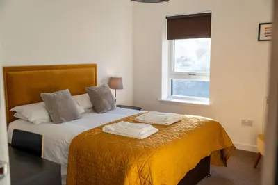 a bedroom with a bed with two towels on it at Aberlour Apartment in Oban
