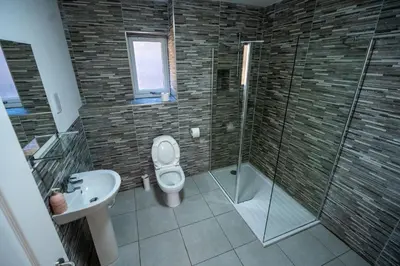 a bathroom with a toilet and a shower and a sink at Aberlour Apartment in Oban