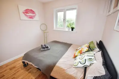a bedroom with a bed in a room with a window at Modern house near Glasgow 3bdr in Dalmuir