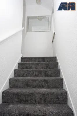 a staircase in a room with grey carpeted stairs at Paisley Haven on Renfrew Road in Merksworth