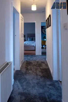 a hallway with a bedroom and a bed in a room at Paisley Haven on Renfrew Road in Merksworth