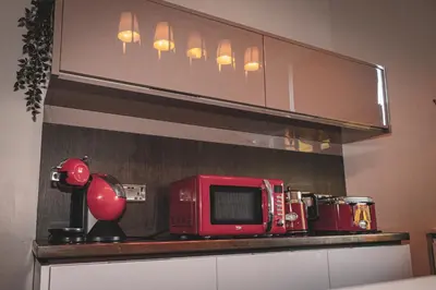 a red microwave sitting on a counter in a kitchen at Spacious 4 Bedroom Flat in Stirling in Stirling