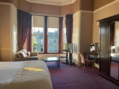 a hotel room with a bed and a desk at Edinburgh Whisky House Hotel in Edinburgh