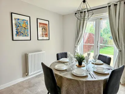 a dining room with a table and chairs and a window at Glasgow Green Modern Stay in Glasgow