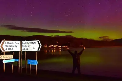 a man standing with his arms in the air under the aurora at Fraoch, Pets welcome in Port Bannatyne