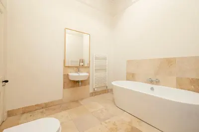 a white bathroom with a tub and a sink at JOIVY Exclusive house with free parking in Edinburgh
