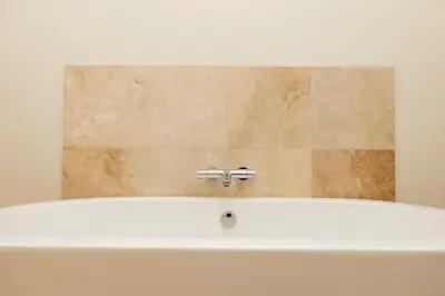 a bath tub with a faucet in a bathroom at JOIVY Exclusive house with free parking in Edinburgh