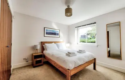 a bedroom with a large bed and a window at Bright & Modern Flat in Edinburgh