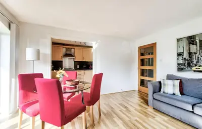 a living room with a table and pink chairs at Bright & Modern Flat in Edinburgh
