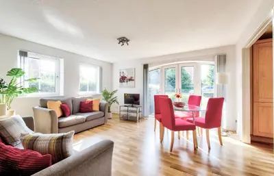 a living room with a couch and a table and chairs at Bright & Modern Flat in Edinburgh