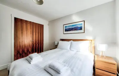 a bedroom with a bed with white sheets and pillows at Bright & Modern Flat in Edinburgh