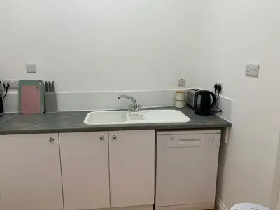 a kitchen with a sink and a counter top at High Street 2 Bedroom Apartment in Ayr