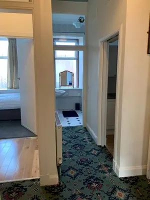 a hallway with a room with a bed and a mirror at High Street 2 Bedroom Apartment in Ayr