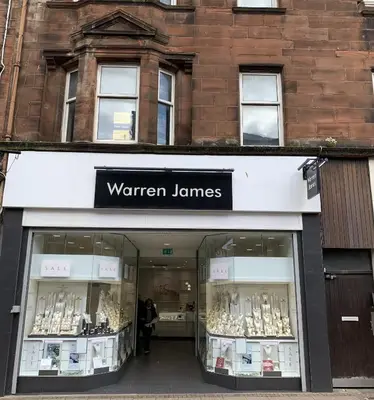 a store front with a sign that reads warren jammers at High Street 2 Bedroom Apartment in Ayr