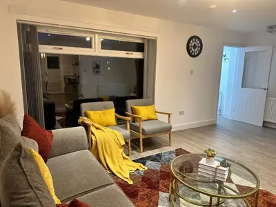 a living room with a couch and a glass table at Elite 3 bedroom family house with free parking in Newton Mearns