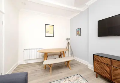 a living room with a table and a tv at Argyl - Charming 2 Bedroom Apartment on Thistle Street in Edinburgh