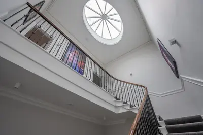 a spiral staircase with a round window on the ceiling at Georgian Gem in the New Town in Edinburgh