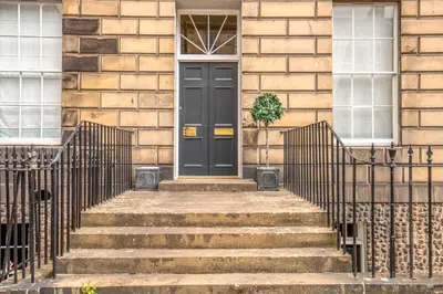 a black door on a house with stairs at Georgian Gem in the New Town in Edinburgh
