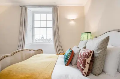 a bedroom with a bed with pillows and a window at Super Central - Georgian Double Upper Flat with Castle Views in New Town in Edinburgh