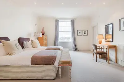 a bedroom with a bed and a table and a desk at Super Central - Georgian Double Upper Flat with Castle Views in New Town in Edinburgh