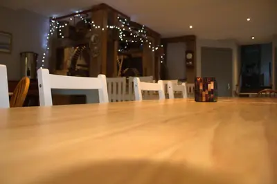 a wooden table and chairs in a room with christmas lights at The Old Mill Bed & Breakfast in Biggar