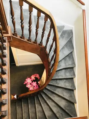 a spiral staircase with a vase of flowers at Burnbank Bed and Breakfast in Moffat